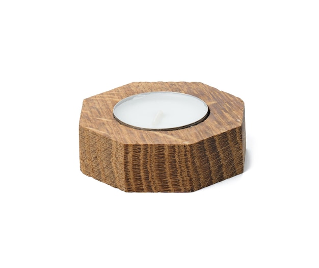 Round white candle in a wooden candlestick on a white isolated background