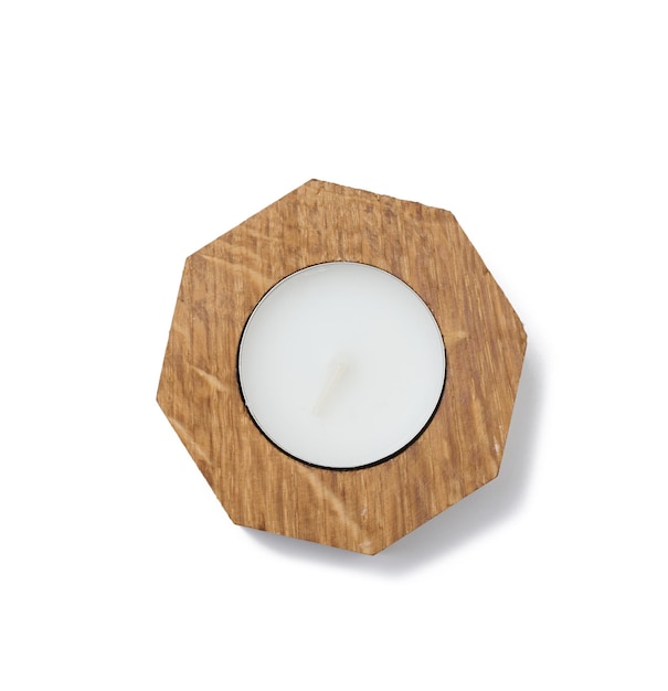 Round white candle in a wooden candlestick on a white isolated background