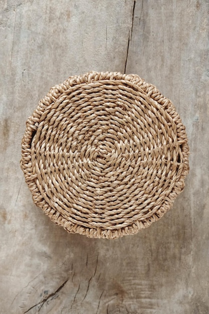 Round wicker basket on a old wooden background. Top view. Copy, empty space for text