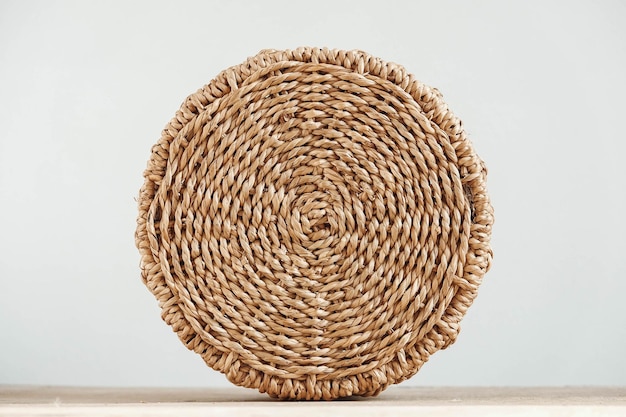 Round wicker basket on a old wooden table. Copy, empty space for text