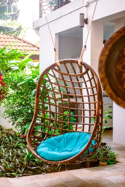 Round wicker hanging chair on the terrace of a villa in a tropical resort Rest and relaxation