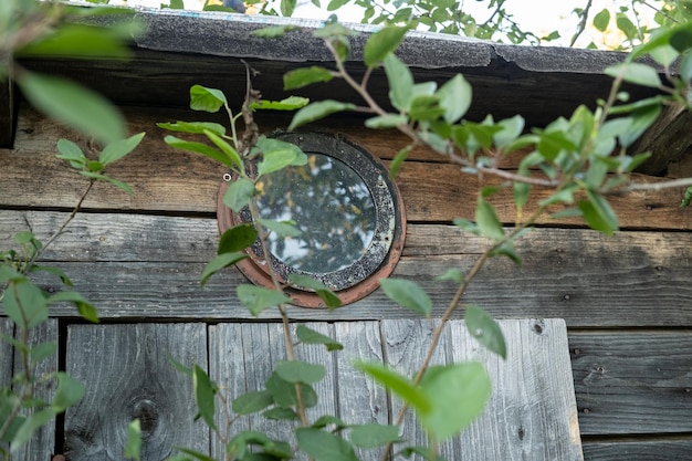 Round window under the roof of an old wooden shed or toilet in a village courtyard