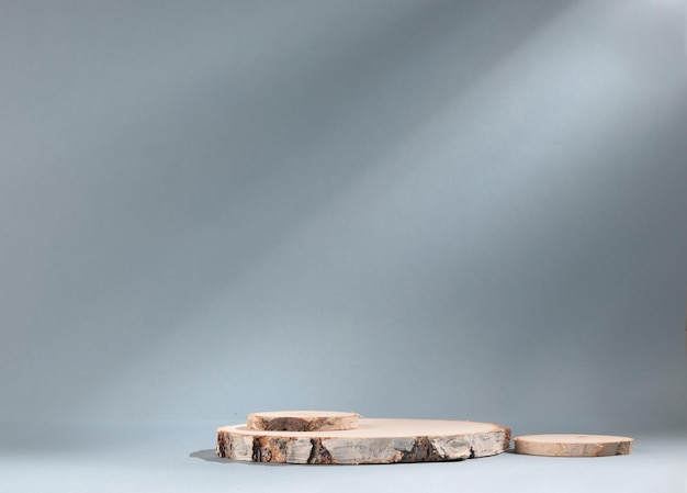 Round wooden slab of cylindrical birch slab on gray background with sunlight Podium. An empty