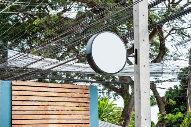 Rounded modern signboard hanging on mortar pole