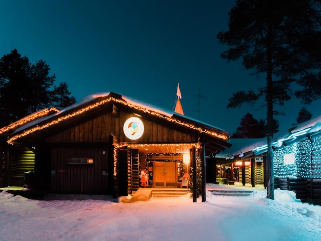 Rovaniemi, Finland - March 6, 2017: Santa Claus Office at Santa Village with Christmas trees in Finnish Lapland. Scandinavia, on Arctic Circle in winter. At night. Outdoor