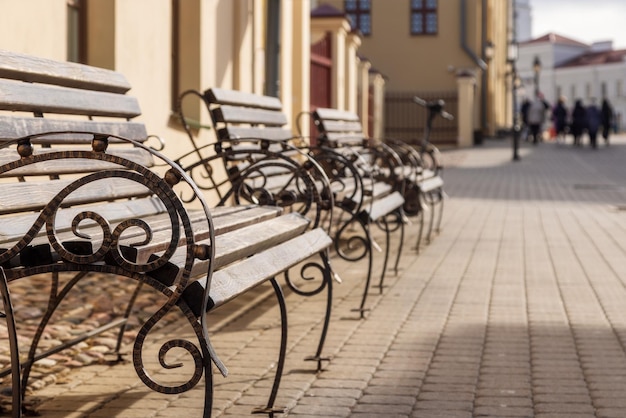 Row of benches on an old street in the city sunny summer day copy space