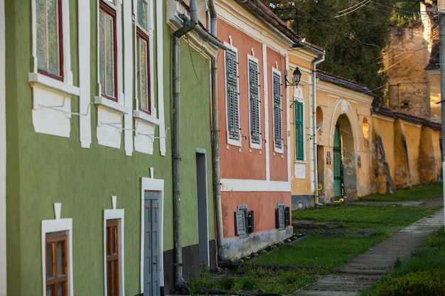 A row of buildings with green and orange walls and a sign that says'the word house '