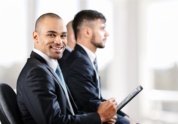 Row of business people sitting at seminar, focus on attentive young female