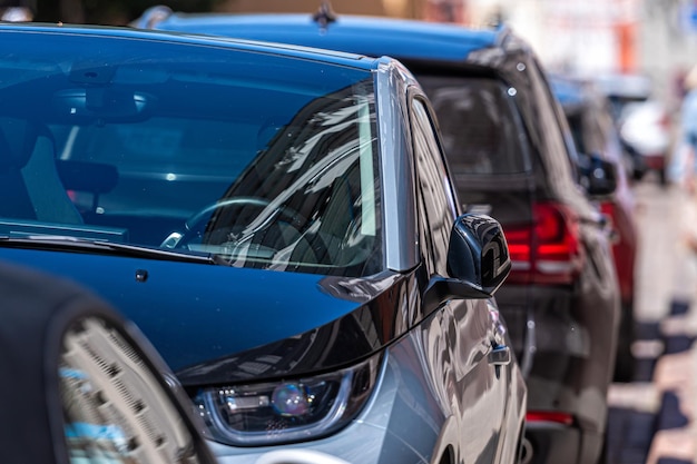 A row of cars parked on the side of the street closeup of body elements and headlights