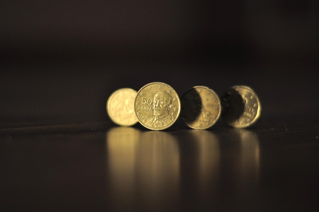 A row of coins with the face of a queen on the bottom.