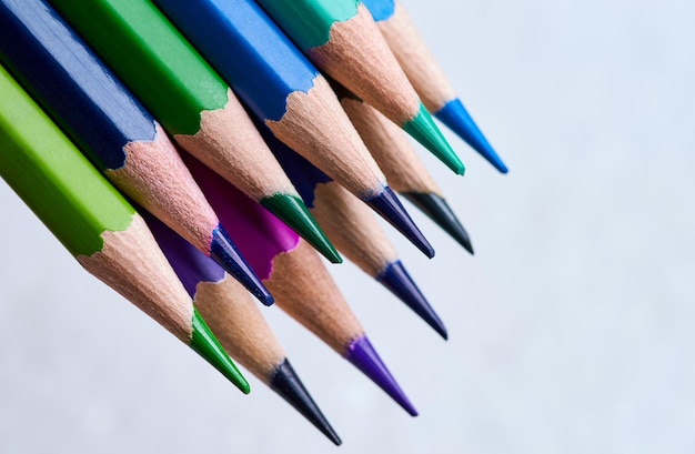 A row of colored pencils are lined up in a row.