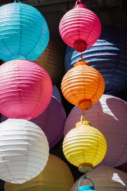 A row of colorful lanterns are hanging in a store.