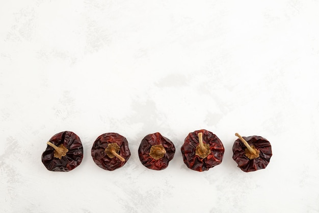 Row of Dried Spanish Nora Peppers on grey textured background Top view copy space.