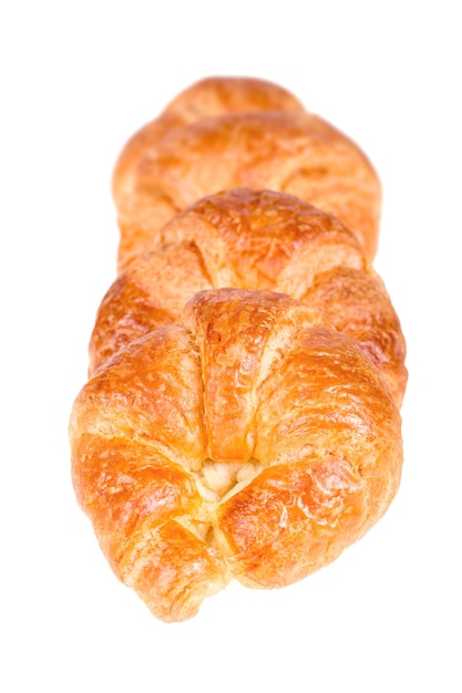 Row of freshly baked croissants isolated over a white background