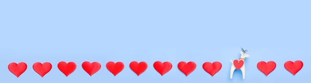 A row of hearts on a blue background with a small figure of a white deer Banner