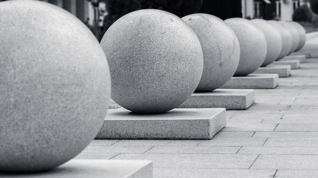 Row of many large granite balls on rectangular bases