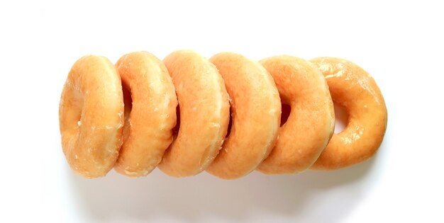 Row of Mouthwatering Sugar-glazed Donuts Isolated on White Background