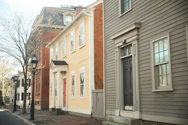 A row of old houses with a red door and a black lamp post.