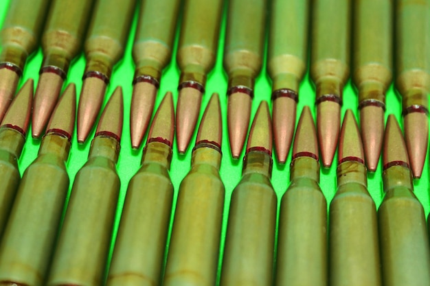 Rows Of Assault Rifle Bullets On A Green Surface Isolated Stock Photo