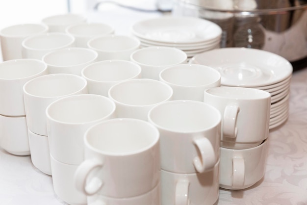 Rows of empty white cups on the buffet table. Business meetings and celebrations. Close-up.