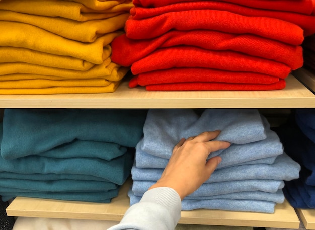 Rows of folded colorful pullover in a shop