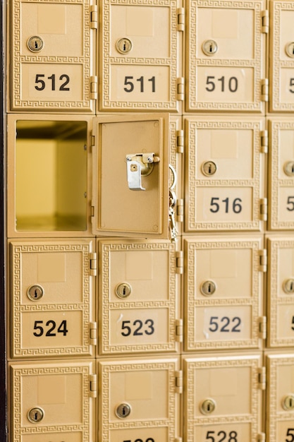 Rows of gold post office boxes with one open mail box.