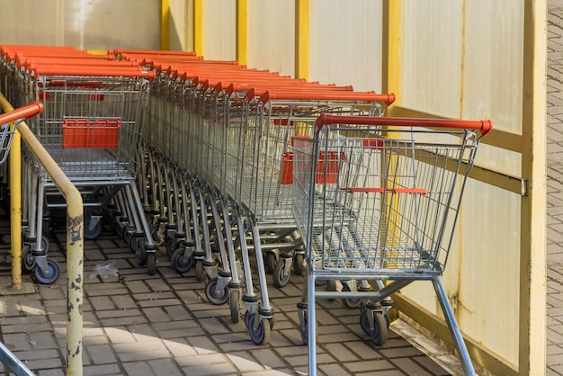 Rows of grocery shopping carts near entrance of supermarket