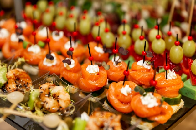 Rows of mouth-watering canapes on the festive table. Catering for business meetings, events and celebrations.