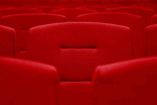 Rows of red velvet seats in a dark and totally empty