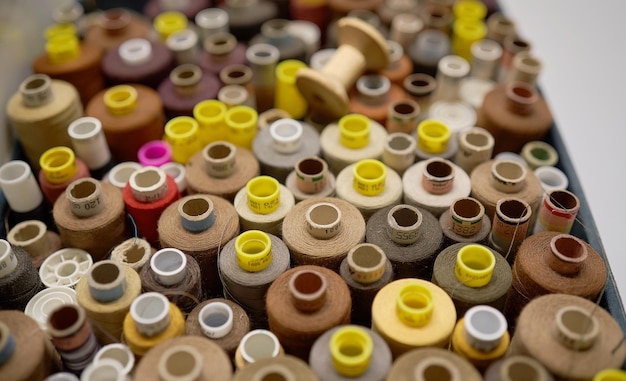 Rows of spools of thread of different colors in a box in the studio