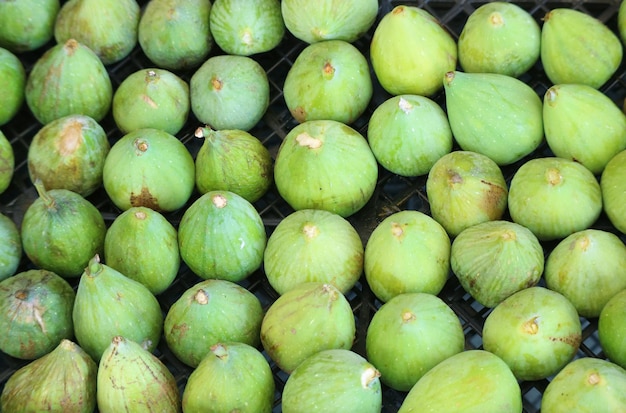 Rows of vibrant green fresh ripe figs for sale on the local market