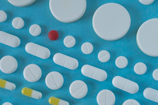 Rows of white pills on blue backgound medicine concept