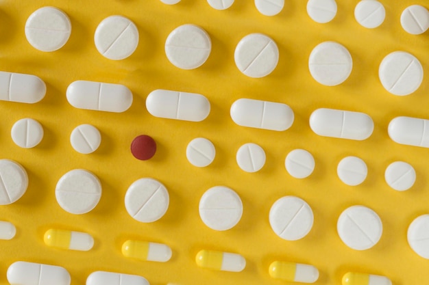 Rows of white pills on yellow background