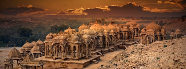 The royal cenotaphs of historic rulers, also known as Jaisalmer Chhatris, at Bada Bagh in Jaisalmer, Rajasthan, India. Cenotaphs made of yellow sandstone at sunset