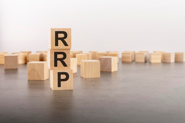 Rrp text as a symbol on cube wooden blocks many wooden blocks in the background