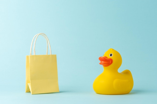 Rubber duck with shopping bag on blue background