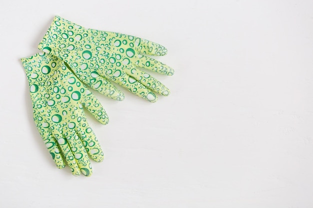 Rubber gloves for garden work on white background. Preparation for the planting season. Selective focus.