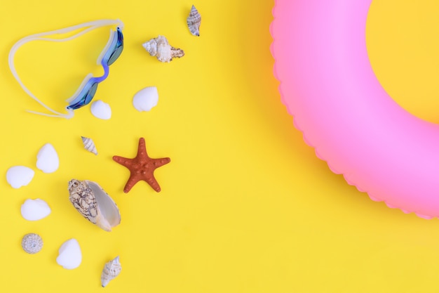 Rubber ring, shells, starfish and glasses for swimming