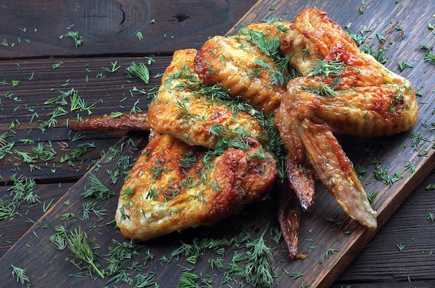 ruddy chicken wings on a wooden table. close up.