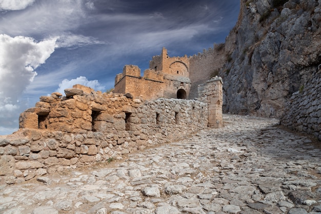 Ruins of the ancient Greek city of Acrocorinth with a stone road, walls and towers, Corinth, Greece