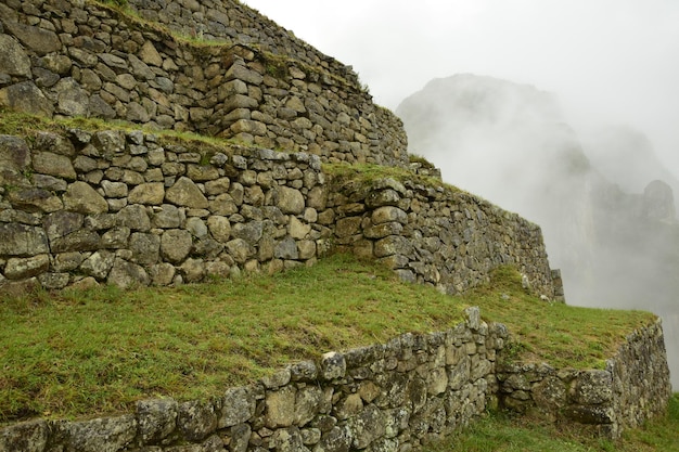 Ruins of the ancient Inca city machu picchu in fog Peru