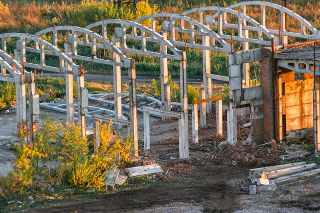 The ruins of an old enterprise in the rays of the setting sun Destroyed old factory Abandoned Industrial Buildings