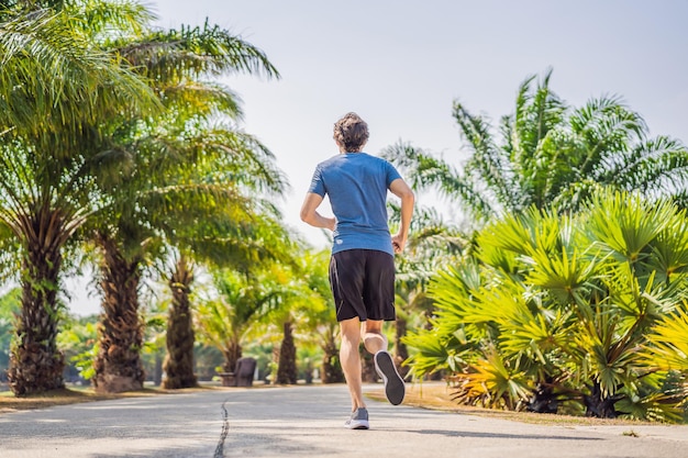 Runner athlete running at tropical park man fitness sunrise jogging workout wellness concept