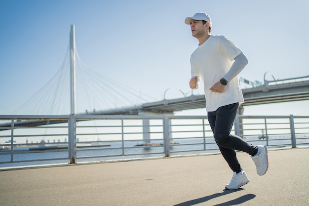 A runner is running a sporty confident man training outside in comfortable sportswear