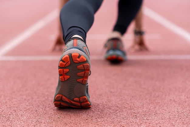 runner legs in a low start position prepared to race along the urban outdoor stadium