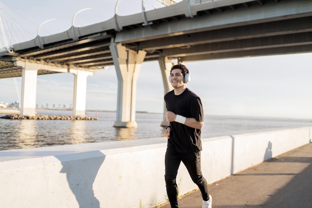 Runner male athlete running does a workout exercise in the city uses a fitness watch