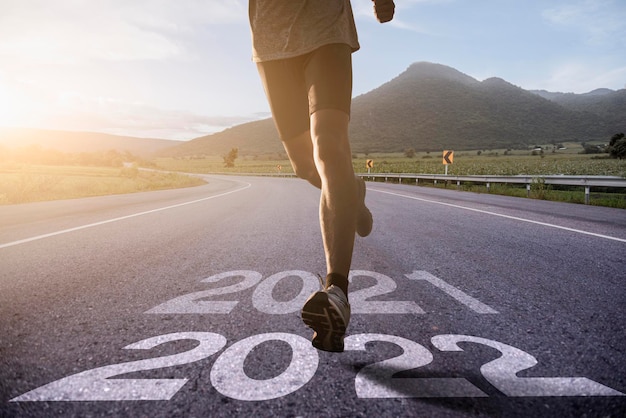 Runner's legs running on the road numbered 2022, Beginning and start of the new year 2022, goals and plans for the next year. Happy new year 2022.