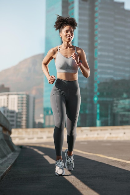 Running fitness and city with a sports woman on a street for a cardio or endurance workout alone in the day Health training and exercise with a female athlete or runner on an asphalt road in town