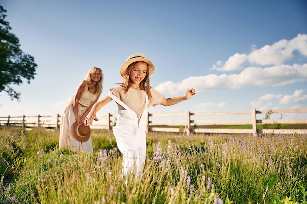 Running having fun Beautiful mother with her daughter on the farm