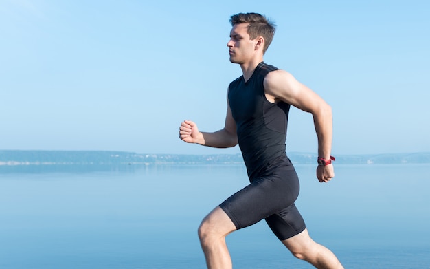 Running man. Male runner at sprinting speed training for marathon outdoors in amazing volcanic desert landscape. Strong and fit caucasian male fitness model.